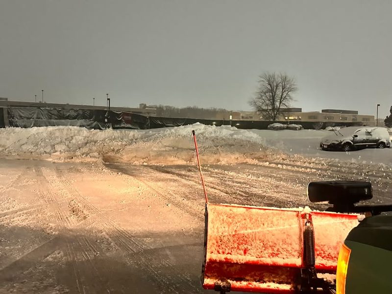 Pushing snow into a stack pile at the far end of a lot.